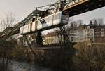Über der Wupper ist der Wuppertaler Schwebebahnwagen 03 am 14.03.2020 von Vohwinkel nach Oberbarmen unweit der Station Loher Brücke unterwegs. Allerdings werden die Fahrzeuge nach den Sommerferien in NRW nur noch an Wochenenden verkehren. Grund sind technische Probleme an den neuen Triebwagen (hoher Verschleiß der Radreifen und fehlerhafte Klebestellen an Dächern und Aufbauten). Montags bis Freitags müssen die Wuppertaler voraussichtlich für ein Jahr auf Busse umsteigen.