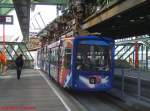 Eine Schwebebahn aus Richtung Vohwinkel schwebt in einer Station ein.
