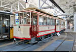 Beiwagen ESS 22, Baujahr 1912, und Triebwagen ESS 7, Baujahr 1912, der ehemaligen Eßlinger Städtische Straßenbahn (ESS) sind im Straßenbahnmuseum Stuttgart ausgestellt.

 Wagen 22 war der einzige Beiwagen, der die Stilllegung der ESS komplett überlebte. Er hatte nämlich erst wenige Jahre zuvor ein neues Untergestell erhalten. Deshalb hat er heute zwar einen Wagenkasten und eine Lackierung wie 1912, das Untergestell ist aber etwas moderner. Anders als alle Beiwagen der SSB besitzt er ein Laternendach, das in Stuttgart nur Triebwagen bekamen. Der Wagen überlebte bei der END, die ihn in Zeiten schwachen Verkehrs einsetzte. 

 Die Esslinger Städtische Straßenbahn eröffnete 1912 den Betrieb. Nachdem man 30 Jahre kaum in den Unterhalt der Strecke investiert hatte, ersetzte man die nun verschlissenen Gleise und Wagen 1944 durch eine neue Obusanlage. Damit ging der Gemeinschaftsbetrieb mit der SSB zu Ende. Die Linie 26 war vom Schloßlatz bis nach Oberesslingen gefahren. Wagen 7 war, als er zur SSB kam, schon 32 Jahre alt, so dass man ihn alsbald nach Reutlingen verkaufte, wo er als Arbeitswagen überlebte. 

[29.7.2020 | 14:23 Uhr]

Textquelle: Informationstafel vor Ort