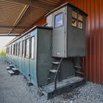 Im Bild ein zu einem Wohngebäude umfunktionierter Abteilwagen mit Bremserhäuschen.