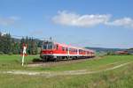 Kurz vor Erreichen des Bahnhofes Weizern-Hopferau passiert eine von 218 467 geschobene RB aus Füssen am 15.09.2014 einen technisch nicht gesicherten Bahnübergang.