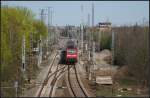 Durch den Mastenwald am Kreuz Genshagener Heide schiebt 143 843-1 die RB14 nach Nauen. Rechts schaut das Stellwerk auf das Geschehen am Kreuz (gesehen Berlin Altglienike 10.04.2011)