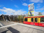 Ein unbekannter Zug der BR485 fuhr auf der S85 in Brlin Richtung Pankow, hier an der Station  Storkower Straße  mit der markanten Brücke über die Fernbahn und einem der bunten Hochhäuser im Hintergrund.

Berlin, der 02.04.2023