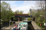 Während sich am 23.4.2016 ein Rundfahrt Schiff in der Schleuse des 
Landwehrkanals in Berlin abwärts senkt, passiert eine S-Bahn im Hintergrund 
die Kanalbrücke vom Bahnhof Zoo kommend in Richtung Hauptbahnhof. 