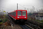 Der DR S-Bahn-Triebwagen 270 063 in der bei der Berliner S-bahn unüblichen rot/schwarzen Lackierung am 13.11.1990 beim Verlassen des Berliner Bf. Warschauer Straße.