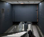 Ein Hohlraum über der S-Bahnstation - 

Bei der Umgestaltung der S-Bahnstation Hauptbahnhof in Stuttgart wurde dieser Raum als ganzes erlebbar, der früher durch stufenförmig abgehängte Decken ein kleineres Volumen hat. Gleichzeitig wurde der Treppenabgang eingehaust, die Öffnungen zum Bahnsteig geschlossen, auf Bahnsteighöhe durch Glaswände und -Türen, die Zwischendecken (rechts und links im Bild) mit Metall. Die Betonwände wurde dunkel gestrichen. Die Zwischendecken animieren manchen Zeitbürger, hier ihre Abfälle zu entsorgen. Zur Zeitpunkt der Aufnahme sieht es aber durchaus sauber aus.
Das vergrößerte Raumvolumen hat sicherlich Brandschutzgründe, da so mehr Platz für den sich ausbreitenden Rauch bleibt, der trotz aller Wände im Brandfall in das Treppenhaus gelangen wird.

09.02.2023 (M)