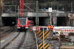 Am Ende des Tunnel wird geschlängelt -

Das Stadtauswärtsgleis der S-Bahn am Bahnhof Stuttgart-Feuerbach wurde auf die Lage des früheren Stadteinwärts-Ferngleis verlegt, dadurch ergab sich direkt nach dem Pragtunnel eine S-Kurve, die die S-Bahn hier gerade befährt. In der rechten Bildmitte ein Haken eines der dortigen Baukräne. Die Arbeiter sind mit dem Haken mit gelaufen. Es ist hier schon passiert, dass mit einem Baukran die Oberleitung heruntergerissen wurde und auf eine S-Bahn fiel. Die Leute waren dann zunächst in der Bahn eingeschlossen. Vielleicht müssen die Arbeiter deshalb aus Sicherheitsgründen bei Lageveränderungen des Hakens unterhalb der Oberleitungshöhe, diesen immer direkt von an Ort und Stelle und von unten aus steuern. Nur mal eine Vermutung, nach der Beobachtung gestern.

14.01.2017 (M)

