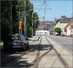 Saarbahn in Riegelsberg: Kurz vor der Haltestelle Post wird die Strecke wieder eingleisig und schwenkt auf eigenen Bahnkörper am Straßenrand.