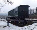 Ein Schmalspur Gepäckwagen der Fichtelbergbahn steht auf einem Normalspur-Rollwagen im Bahnhof Cranzahl.