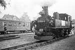 29. September 1984, Schmalspurbahnhof Mügeln. Die Mügelner Schmalspurbahn feierte an diesem Wochenende ihr 100-jähriges Bestehen. Gleichzeitig konnte die Stadt Mügeln auf eine 1000-jährige Geschichte zurückblicken. Verschwiegen wurde auch nicht, dass auch die DDR ein rundes Jubiläum feierte, sie wurde vor 35 Jahren gegründet. Schilder und Fähnchen wiesen an den Lokomotiven auf diese Ereignisse hin. Lok 99 564 rangiert.