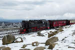 Der Dampfzug aus Wernigerode fährt im winterlichen Bahnhof auf dem Brocken ein. Brocken, 17.4.2024