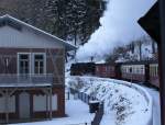 99 7237 mit P8937 in Richtung Brocken am 25.01.2013 kurz vor Erreichen der Haltepunktes  Steinerne Renne . Hier beginnt die Steigung nach Drei Annen Hohne und in den Oberharz, wobei auch der einzige Tunnel der Harzer Schmalspurbahnen durchquert wird. Zahlreiche Sandhufchen an den Schienen zeugen davon, wie schwer das Anfahren an dieser starken Steigung ist. Hier ist vom Lokfhrer wirklich absolutes Fingerspitzengefhl am Regler gefragt. Der Klang der Auspuffschlge der anfahrenden Lok ist an dieser Stelle brigens jedesmal genial! Ein regelrechtes Brllen, welches durch den Wald schallt und von den umliegenden Berghngen vielfach widergegeben wird! Das mu man einfach gehrt haben! Im links zu sehenden Gebude befindet sich ein kleines Wasserkraftwerk.