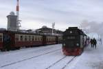 Bahnhof Brocken am Nachmittag des 26.01.2013. Links, auf Gleis 1, steht P8929, welcher unter Traktion von 99 7241, in Krze nach Nordhausen aufbrechen wird, rechts auf Gleis 3 der Sonderzug  Quedlinburger Brockenexpress  mit 99 7245, mit Fahrziel Wernigerode. Neben dem Sendemast im Hintergrund links, befindet sich der Aussichtsturm, in welchem, neben Hotelzimmern, auch ein Cafe und im darunterliegenden Gebude, auch ein Restaurant untergebracht ist, wo man sich aufwrmen und auch gut brgerlich und relativ preiswert speisen kann. Wer nicht so gut zu Fu ist, kann dies brigens auch direkt im Brockenbahnhof tun, wobei die dortige kleine Gaststtte meist hoffnungslos berfllt ist. Hier gilt:  Rechtzeitiges Kommen sichert gute Pltze !