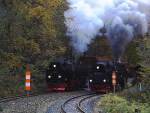 Doppelausfahrt von 99 222 mit Foto-Güterzug der HSB (links auf der Selketalbahn) und 99 7245 mit P8904 nach Wernigerode am Nachmittag des 19.10.2013 aus dem Bahnhof  Eisfelder Talmühle  (Bild 1). Während der Personenzug seine Fahrt ohne Halt fortsetzt, wird der Güterzug nach Passage der Fotostelle anhalten und danach in den Bahnhof zurückgedrückt werden.
(Anmerkung zum Aufnahmestandort: Der Standort befindet sich an der Waldzunge genau zwischen der Gleisgabelung von Selketal- und Harzquerbahn, kurz hinter dem Bahnhof  Eisfelder Talmühle . Die Doppelausfahrt war speziell zu einem Fototermin für die Fahrgäste eines Sonderzuges der IG HSB organisiert (geplanter Bestandteil der Sonderfahrt), der Standort vorher genau festgelegt, von der Betriebsleitung der HSB genehmigt und durch Mitarbeiter der IG HSB überwacht und abgesichert worden, welche mit Argusaugen und Warnweste sowie  Meckertüte  (Megafon) bewaffnet, genauestens darauf achteten, dass keines ihrer  Schäfchen , und das waren immerhin 30-40, verlorenging oder sich gar in Gefahr brachte. Ich versichere, dass die Aufnahme somit absolut legal und keinesfalls eigenmächtig entstand!)