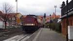 Während die Dampfloks nebenan schon für ihre Bergfahrt bereit gemacht werden, schiebt ein  Harzkamel , 199 872-3, die Wagen für den Personenzug in den Bahnhof.
