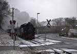 Winterliches Wetter am BÜ in Berbisdorf, kurz vor Radeburg, 99 1761-8 mit einem kurzen,leider  wieder fast unbesetzten Zug nähert sich, von Moritzburg kommend.