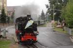 99 1777 hat am Mittag des 31.08.2012  mit ihrem Zug P 3006 nach Moritzburg soeben den Bahnhof Radebeul-Ost verlassen, die Schildenstrae berquert und schwenkt jetzt auf die Pestalozzistrae ein,