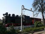 Der noch vorhandene Wasserkran am Randes des Bahnhof Bad Khlungsborn-West mit 99 332 und geschlossenem historischen gedeckten Gterwagen im Hintergrund. (26.03.10)