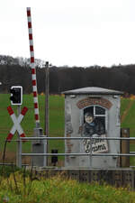 Schranke und Andreaskreuz am Bahnübergang in Serams.