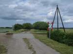 Ein unbeschrankter Bahnbergang fr ein Feldweg,am 17.Juni 2012,beim Rasenden Roland in der Nhe vom Dorf Beuchow.