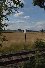 Etwas windschief steht das Pfeifsignal links neben dem Gleis.
