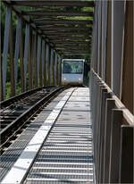 Die Bergbahn Künzelsau -     Hier blickt man den Wartungs- und Fluchtweg entlang zu einer Bahn, die in den Fachwerkabschnitt der Brückenstrecke eingefahren ist.