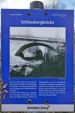 Der Geschichtspfad in Friedrichshafen führt auch zur Schlossbergbrücke, die die Bodenseegürtelbahn überspannt und an der diese Tafel aufgestellt ist (12.03.2021). 
„Am 29.12.1873 wurde durch Staatsvertrag zwischen Baden und Württemberg das Teilstück der Bodensee-Gürtelbahn von Überlingen nach Friedrichshafen beschlossen. Im März 1900 erhielten die Unternehmen Trautmann und Weißflog den Auftrag, den Bahneinschnitt zwischen der Zeppelinstraße und der Schmidstraße auszuheben. Italienische Bauarbeiter realisierten das Vorhaben samt den zwei Brücken über die Bahnlinie im Zuge der Schlossstraße und der Werastraße innerhalb von fünf Monaten.“