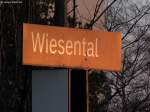 Das Bahnhofsschild von Wiesental erstrahlt in der tiefstehenden goldenen Abendsonne.