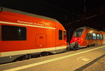 Ein FLIRT und ein TALENT 2 stehen sich in der Nacht am Bahnsteig in Sassnitz gegenüber.