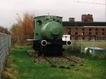 Feuerlose Lok “Baumwollspinnerei 1” (Borsig, Fabriksnummer 7595, Baujahr 1910) der Eisenbahnfreunde Gronau als Denkmal auf dem Gelnde der ehemaligen Textilfabrik van Delden in Gronau am 19-11-2000. Bild und scan: Date Jan de Vries.