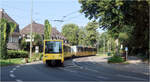 Entlang der Essener U17 -     Ein Ex-Londoner Stadtbahnzug in Fahrtrichtung Innenstadt verlässt in S-förmiger Streckenführung den begrünten Bahnkörper und wird gleich die