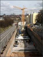 . Stadtbahnbau in Stuttgart -

Vom selben Standpunkt auf der Fußgängerbrücke ein Blick auf die Baustelle in anderer Richtung in Richtung Neckartal. Auf höhe der Baukräne entsteht die im Trog liegende Station Bottroper Straße, die einen Mittelbahnsteig erhält. Hinter der Haltestelle wird die Stadtbahn in einem 480 m langen Tunnel verschwinden, der teils bergmännisch und teils in offener Bauweise gebaut wird. Der bergmännische Anteil wird dieser Tage durchstoßen. 

04.03.2015 (Matthias)