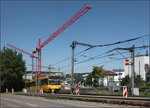 . Heute hier keine gute Fotostelle -

An etwa der selben Stelle südlich des Bahnhofes Stuttgart-Feuerbach an der Horst 1978 einen GT 4 auf der Linie 13 fotografierte, ist es heute fast nicht mehr möglich eine brauchbare Stadtbahn-Aufnahme zu machen.

http://www.bahnbilder.de/bild/deutschland~strassenbahn~stuttgart-keine-stadtbahn/896327/aus-feuerbach-kommend-faehrt-gt4-496.html

Schon sechs Jahre nach der Aufnahme von Horst wurde die Straßenbahn auf diese neue völlig unabhängige Trasse verlegt. Diese entstand im Zusammenhang mit dem Tunnelbau unter der Siemenstraße mit der U-Haltestelle Maybachstraße. Die Leitplanke, links die Betonmauer und aktuell die rot-weißen Baken verhindern einen störungsfreien Blick auf Stadtbahn.

Das Gebäude mit dem Walmdach hier zwischen den massiven Oberleitungsmasten ist auf Horsts Bild hinter den Bäumen auch sichtbar. Weitgehend gleich ist der jetzt zur Baustelle gewordene Bahnhof, die dahinterliegende Bebauung hat sich dagegen völlig gewandelt. 

Zur Zeit gibt es hier wiederum große Veränderungen durch den Tunnelbau für Stuttgart 21. Der Tunnel wird hier unter den Stadtbahngleisen und der Straße im Vordergrund verlaufen.

19.07.2016 (M)