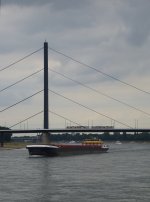 Reichlich Verkehr in Dsseldorf -    Whrend auf dem Rhein ein groes Containerschiff tuckert, fhrt oben auf der Obberkasseler Brcke eine Stadtbahn ihrer nchsten Haltestelle  Luegeplatz  entgegen.