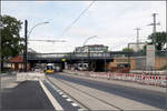 Straßenbahn-Ausbau am S-Bahnhof Berlin-Karlshorst -

Die Bahnbrücke wurde hier neu gebaut mit einem breiteren Querschnitt für die Straße von bisher zwei Fahrspuren mit Straßenbahngleisen zu zukünftig vier Fahrspuren. Zusätzlich wurde auf der Westseite der Brücke ein neuer Zugang zur östlich der Brücke liegenden S-Bahnstation geschaffen. Dafür entstand eigens für den Zugang von der Westseite ein überdachter Steg zwischen den Bahngleisen, im Bild erkennbar.

Bisher gab es keine direkt am S-Bahnhof liegende Straßenbahn-Haltestelle. Diese wird jetzt direkt unter der Brücke angelegt. Dabei schwenken die Gleise der Straßenbahn vom eigenen Bahnkörper nördlich der Brücke auf die außen liegende Straßenfahrbahnen, der vierspurigen Straße. Unter der Brücke, wo im Bild die Straßenbahn zu sehen ist, wird zukünftig auf der Straße angehalten. Zwischen den neuen Bahnsteigen der Haltestelle und dem Gehweg bzw. den S-Bahnzugängen müssen nur noch die Radwege überquert werden.

Südlich der Brücke bleibt das südwärts führende Gleis noch in Seitenlage auf eigenem Bahnkörper neben einem grünen Platz (im Bild vorne, hier auch die momentan genutzte Ersatzhaltestelle). An der folgenden Kreuzung wechseln die Gleise wieder auf den eigenen Bahnkörper in Mittellage.

Ich hoffe ich habe die Baumaßnahmen einigermaßen richtig verstanden.

20.08.2019 (M)

 