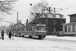 28. Januar 1985, an der stadtwärtigen  Haltestelle  Straßenbahnhof Tolkewitz  steht ein Tatra-Zug der Linie 2. In dem rechts angeschnittenen Geschäft gab es tatsächlich ab und zu Ersatz- und Zubehörteile für Skoda-Pkw und MZ-Motorräder. 