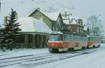 Dresden: Ein TATRA-Zwei-Wagen-Zug, hält am Straßenbahnhof Tolkewitz. Tw 222 436 führt. Hinter dem Fotografen befindet sich eine große Friedhofsanlage. Die Häuser im Hintergrund beherbergen dementsprechend ein Blumengeschäft, einen Steinmetzbetrieb und eine Konditorei. 