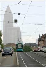 Der Messeturm im Dunst -    Ein S-Triebwagen auf der Friedensbrücke über den Main kurz vor einem Regenschauer.