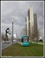 S-Triebwagen 202 am 13.02.2007 auf dem 7. Zug der Linie 16 nach Stadtgrenze Offenbach kurz vor der Haltestelle Festhalle/Messe. Am Bildrand links ist das Kunstwerk  Hammering Man  des US-amerikanischen Knstlers Jonathan Borofsky zu sehen.