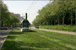 Mit der Straßenbahn durch den Freiburger Westen -    Auf einer grünen Wiese erreicht der Combino auf der Fahrt in Richtung Innenstadt gleich die Haltestelle 'Am Bischofskreuz.'    11.05.2006