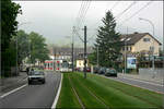 Mit der Straßenbahn nach Freiburg-Vauban -    Blick von der Haltestelle 'Peter-Thumb-Straße' nach Süden in Merzhauser Straße mit dem Rasenbahnkörper in Mittellage.