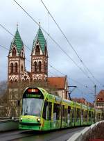Tw 289 der Freiburger Straßenbahn erreicht am 02.01.2014 die Haltestelle Hauptbahnhof, im Hintergrund die 1897 geweihte, im Stil des Historismus gebaute Herz-Jesu-Kirche