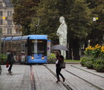 Ob man die Tram wohl beachtet hat? Eine Tram der Linie 19 (Pasing Bf - St.-Veit-Straße) nähert sich der Station Theatinerstraße. Im Hintergrund ist die  Statue des Roland de Lattre  zu erkennen.
München, Theatinerstraße, 12. August 2016