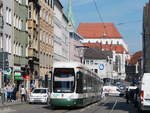 Eine Straßenbahn fährt die Karolinenstraße entlang; im Hintergrund steht der Augsburger Dom.