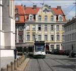 Die Straßenbahn im Stadtbild von Augsburg -     Hier kommt eine Combino-Straßenbahn am Dom um die Ecke, umgeben von historischer Bebauung.