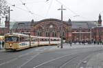 Der museal erhaltene Bremer GT4c 445 verlässt am 27.11.2022 mitsamt passendem Beiwagen die Haltestelle am Hauptbahnhof und beginnt seine Ringbahnfahrt durch die Innenstadt, im Hintergrund das von