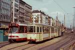 Im Sommer 1979 begegnen sich im Sommer 1979 zwei Rheinbahn-Züge der Linie 15 auf der Heinrich-Heine-Allee, links der fast noch nagelneue GT8S 3031, daneben ein Vierachserzug mit dem Bw 1618 am Schluss. Die Rammen im Hintergrund sind ein sichtbares Zeichen, dass die Arbeiten für den U-Bahn-Bau begonnen haben. Kurz danach wurde das vom GT8S befahrene Gleis stillgelegt und durch eine neue Streckenführung durch die Bolker- und Hunsrückenstraße ersetzt.