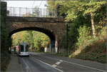 Unter der Brücke -    Eine NF10-Straßenbahn der Linie 709 fährt in grünen Umfeld die Ludenberger Straße in Richtung Gerresheim Krankenhaus hinauf.