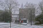 Während eines heftigen Schneeschauers erreicht der Rheinbahn-NF10 2025 am 17.01.2024 die Haltestelle Stadthalle/Museum an, im Hintergrund das Neusser Obertor