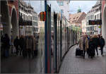 Die Straßenbahn als Spiegel in der Stadt -    Combino-Tram in Freiburg am Bertoldsbrunnen.